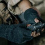 Survivor Prepper communicating with a radio in the forest.