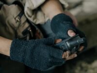 Survivor Prepper communicating with a radio in the forest.