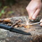 Prepper trying to start a fire in the forest.
