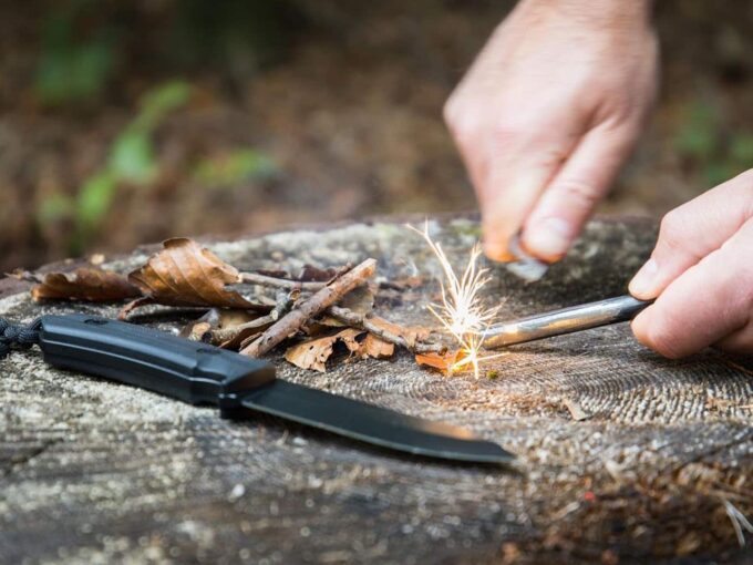 Prepper trying to start a fire in the forest.