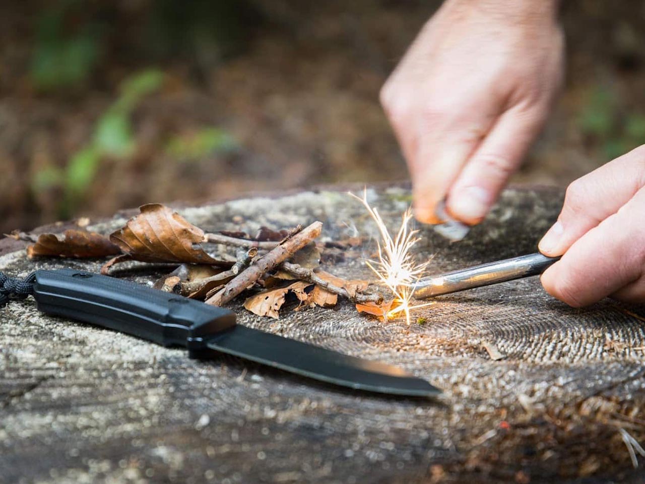 Prepper trying to start a fire in the forest.